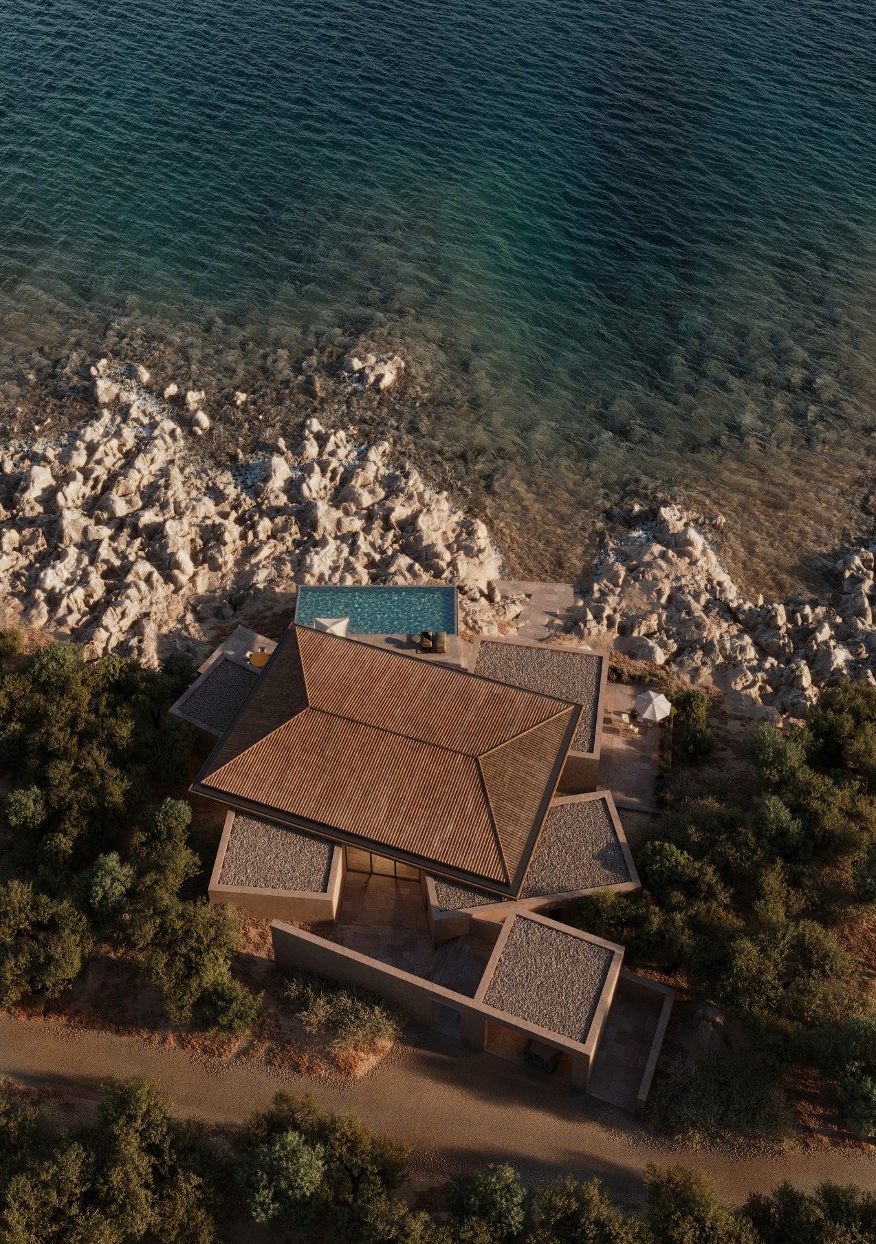 Elite villa with a tiled roof seen from directly above, on the rocky shore