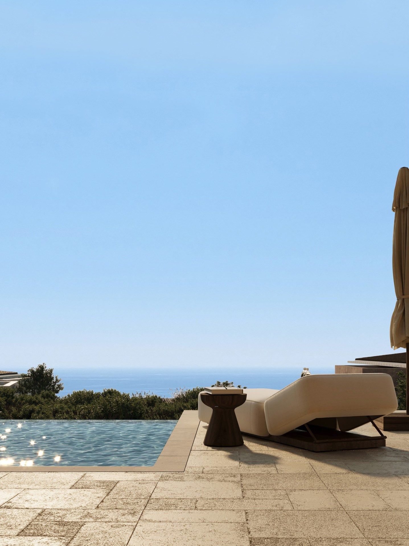 Sun lounger beside a pool with the sea on the horizon